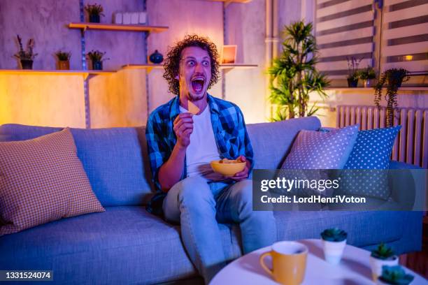 man scared by horror movie - bad news on tv stock pictures, royalty-free photos & images