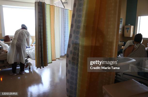 Registered nurse cares for a COVID-19 patient as another COVID-19 patient rests in the improvised COVID-19 unit at Providence Holy Cross Medical...