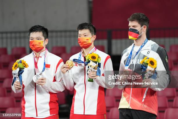 Silver medalist Fan Zhendong of Team China, gold medalist Ma Long of Team China and bronze medalist Dimitrij Ovtcharov of Team Germany celebrate on...
