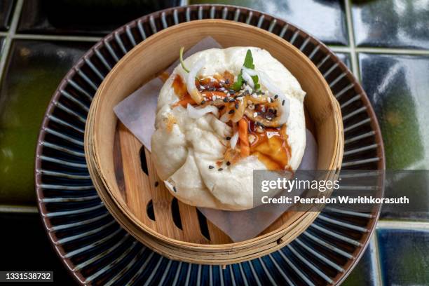 top view of banh bao,  vietnamese bun with chicken meat, onions and mushrooms serve on bamboo streamer. vietnamese breakfast. - dim sum stock-fotos und bilder