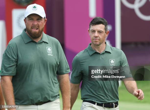 Shane Lowry of Team Ireland and Rory McIlroy of Team Ireland walk off the first tee during the third round of the Men's Individual Stroke Play on day...