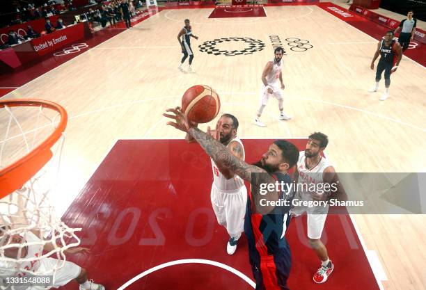 Hamed Haddadi of Team Iran goes up for a shot against Vincent Poirier of Team France during the first half of a Men's Basketball Preliminary Round...