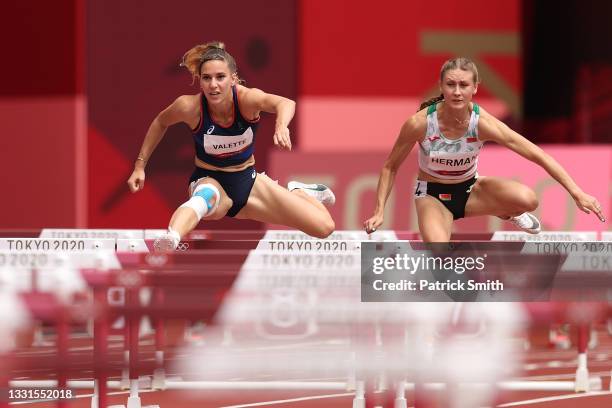 Laura Valette of Team France and Elvira Herman of Team Belarus compete in round one of the Women's 100m hurdles heats on day eight of the Tokyo 2020...