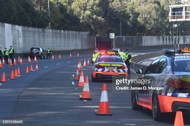 Police road block on the Bradfield Highway to check cars as they approach the Harbour Bridge in the suburb of Artarmon on July 31, 2021 in Sydney,...