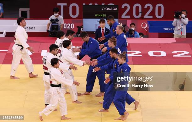 Team Japan and Team Germany shakes hands after the the Mixed Team Quarter Final on day eight of the Tokyo 2020 Olympic Games at Nippon Budokan on...