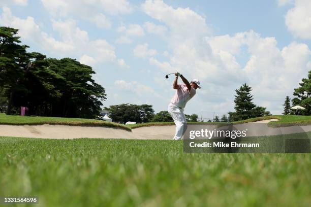 Hideki Matsuyama of Team Japan plays a shot from a fairway bunker on the ninth hole during the third round of the Men's Individual Stroke Play on day...