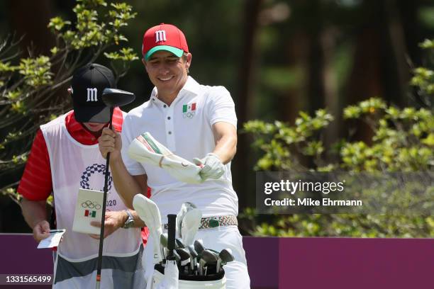 Carlos Ortiz of Team Mexico smiles as he talks with caddie Mike Kerr on the ninth tee during the third round of the Men's Individual Stroke Play on...