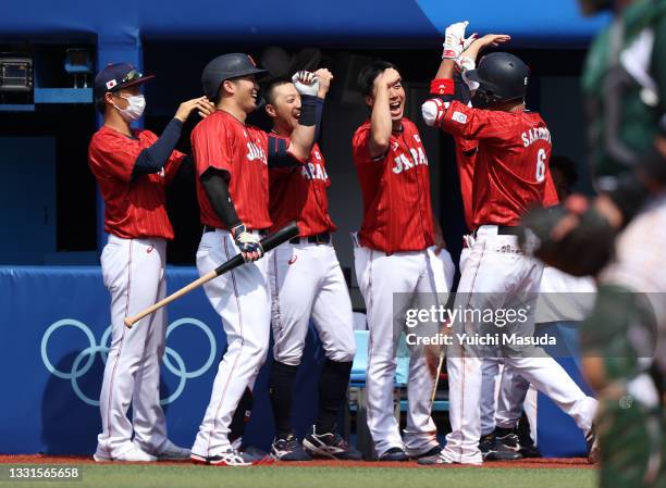 Hayato Sakamoto of Team Japan is congratulated by teammates at the dugout after hitting a solo home run in the seventh inning against Team Mexico...