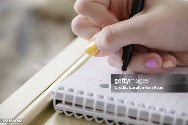 teen girl beginning to take notes during virtual school - écriture photos et images de collection