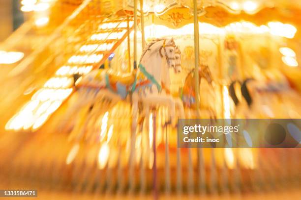 merry-go-round in the blurred lights - karussell stock-fotos und bilder