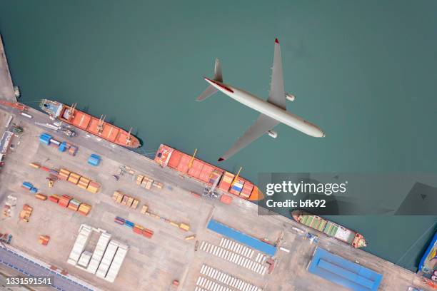 airplane flying above cargo ship. - air freight transportation stock pictures, royalty-free photos & images