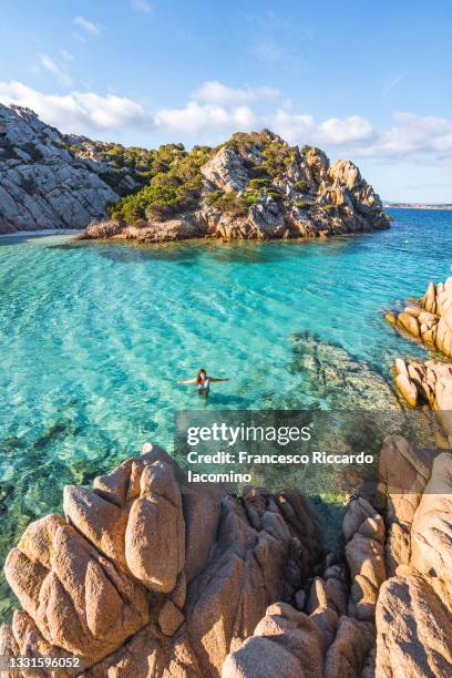 woman taking a bath at cala napoletana, beautiful bay in caprera, la maddalena archipelago, sardinia, italy - iacomino italy stock-fotos und bilder