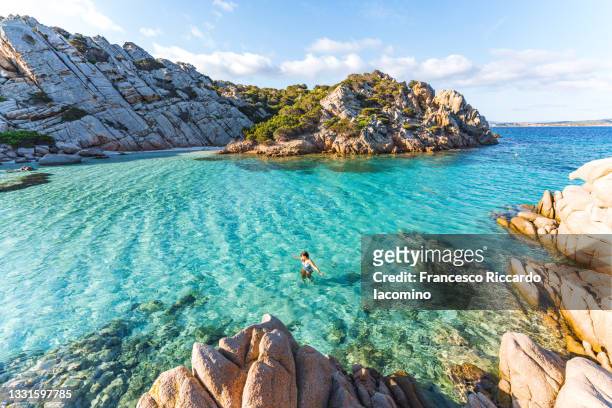 woman swimming at cala napoletana, beautiful bay in caprera, la maddalena archipelago, sardinia, italy - costa caratteristica costiera foto e immagini stock