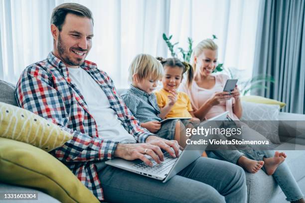 relaxing at home with wireless technology. - mother and son using tablet and laptop stock pictures, royalty-free photos & images