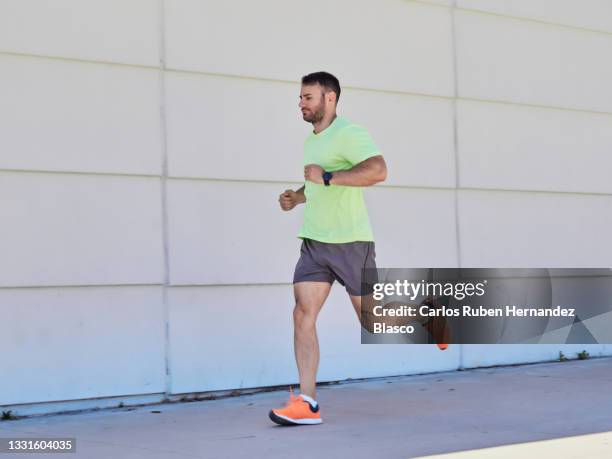 young man running in the street. workout concept - urban running foto e immagini stock