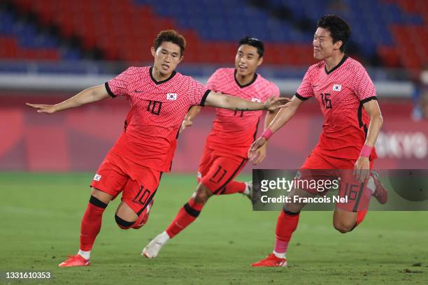 Donggyeong Lee of Team South Korea celebrates with teammate Uijo Hwang after scoring their side's first goal during the Men's Quarter Final match...