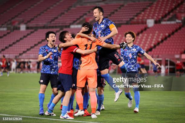 Maya Yoshida of Team Japan celebrates with team mates following their team's victory in the penalty shoot out during the Men's Quarter Final match...