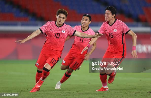 Donggyeong Lee of Team South Korea celebrates with teammate Uijo Hwang after scoring their side's first goal during the Men's Quarter Final match...