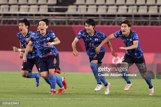 Wataru Endo, Koji Miyoshi, Kaoru Mitoma and Daiki Hashioka of Team Japan celebrate following their team's victory in the penalty shoot out during the...