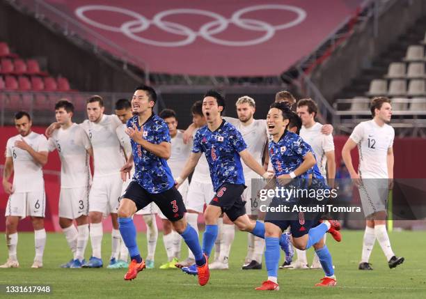 Yuta Nakayama, Wataru Endo and Koji Miyoshi of Team Japan celebrate following their team's victory in the penalty shoot out after the Men's Quarter...