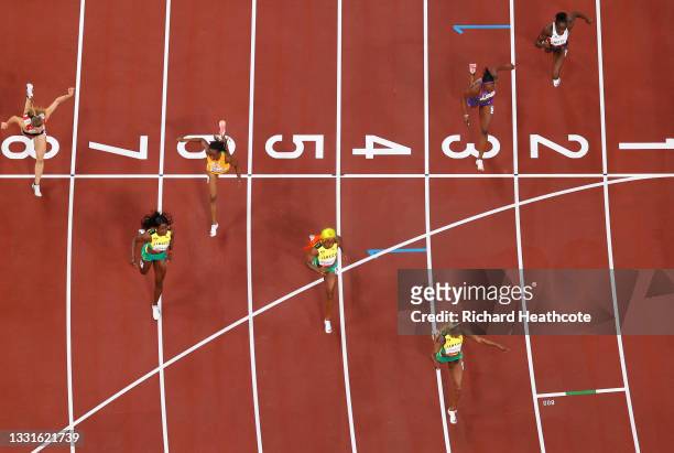 Elaine Thompson-Herah of Team Jamaica crosses the finish line to win the gold medal ahead of Shelly-Ann Fraser-Pryce and Shericka Jackson of Team...