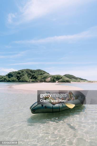 young girl and her grandfather kayaking on clear water, iki island, japan - cay insel stock-fotos und bilder