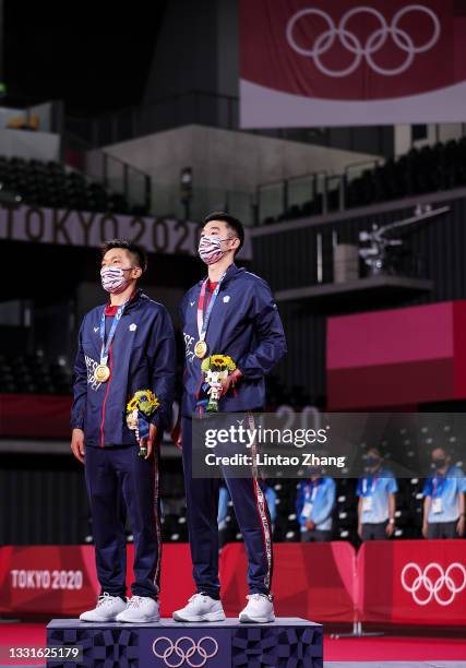 Gold medalists Lee Yang and Wang Chi-Lin of Team Chinese Taipei pose on the podium during the medal ceremony for the Men’s Doubles badminton event on...