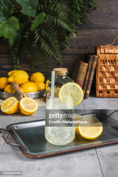hausgemachte limonade in rustikaler küche mit frischen zitronen - zitruszeste stock-fotos und bilder