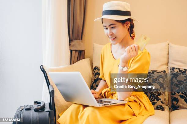 happiness woman in yellow dress holding a credit card for making a payment online by laptop. - yellow dress stock pictures, royalty-free photos & images