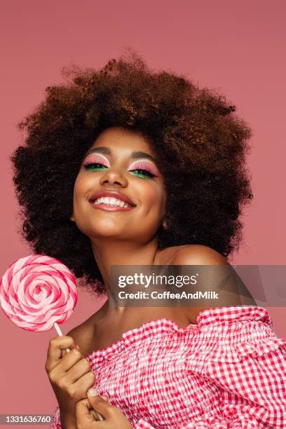 pretty young afro woman holding a lollipop - funky woman stock pictures, royalty-free photos & images