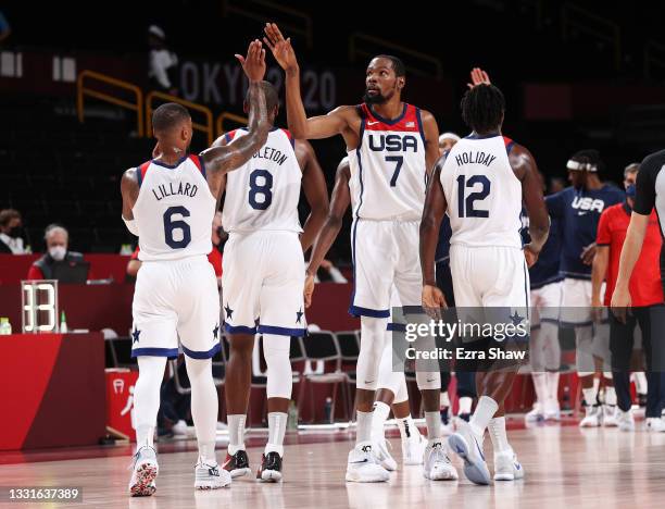 Kevin Durant of Team United States high-fives teammates Damian Lillard of Team United States during the second half of a Men's Basketball Preliminary...