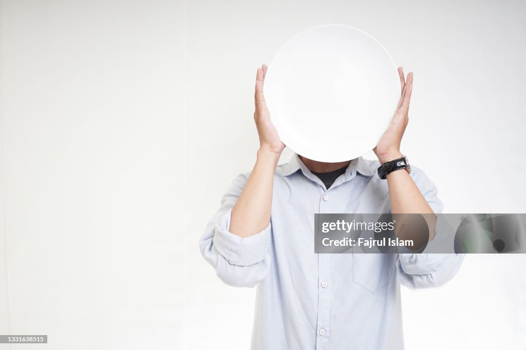 Covering face with white plate