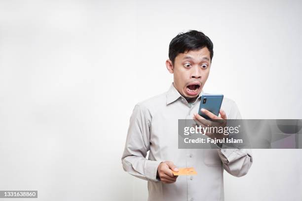 shock expression while pay credit card bills - phone credit card photos et images de collection