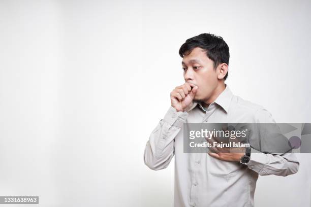asian young men is coughing as a covid symptoms - husten stock-fotos und bilder