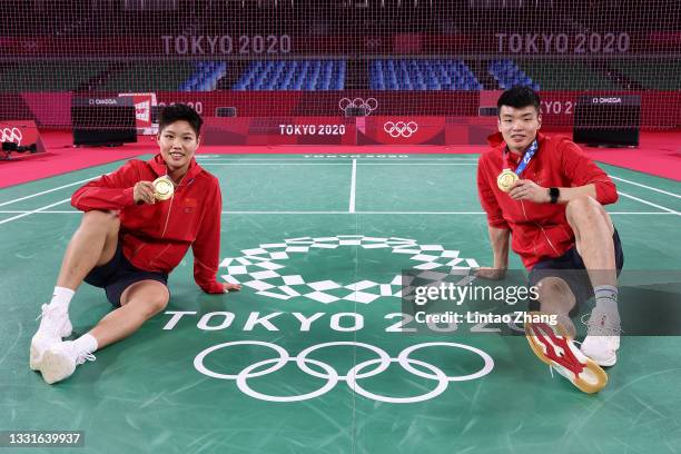 Gold medalists Wang Yi Lyu and Huang Dong Ping of Team China pose with their medals after winning the Mix Doubles badminton event on day eight of the...