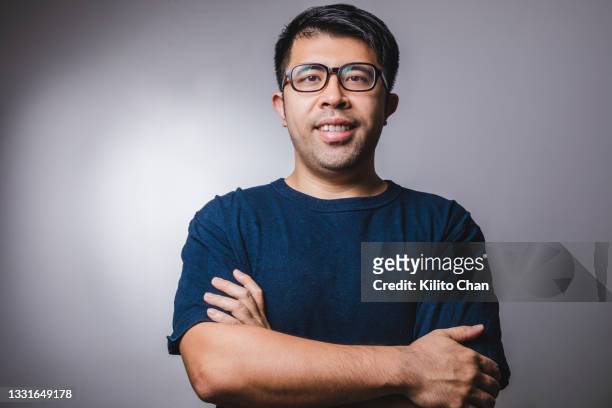 studio shot portrait of an asian man standing with arm crossed - asian man studio shot stock pictures, royalty-free photos & images