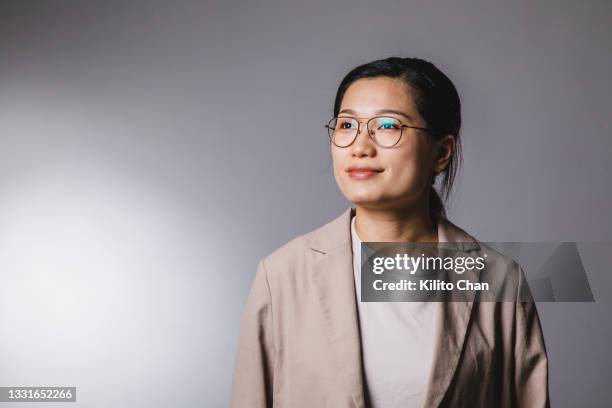 studio shot portrait of asian businesswoman looking up to the side - confidence studio shot stockfoto's en -beelden