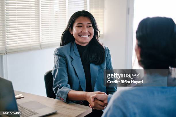 young woman interviewer interviewing young candidate and shaking hand - recruiter bildbanksfoton och bilder