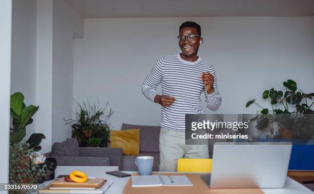 excited young man dancing and singing at home - music headphone express stock pictures, royalty-free photos & images
