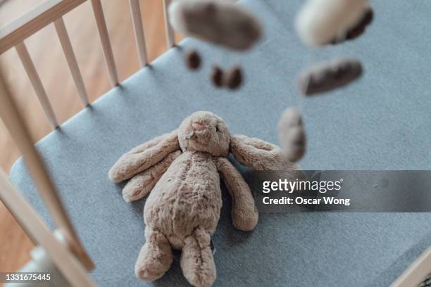 stylish scandinavian newborn baby nursery with natural wooden baby cot, stuffed bunny and handmade hanging mobile - mobile imagens e fotografias de stock