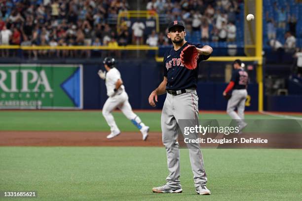 Nathan Eovaldi of the Boston Red Sox receives the ball from the catcher as Ji-Man Choi of the Tampa Bay Rays rounds the bases after hitting a two run...