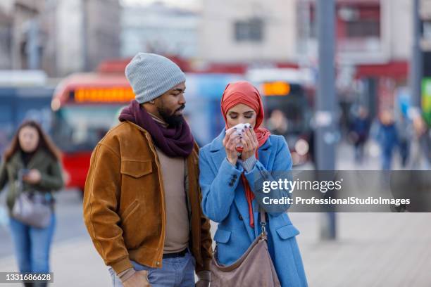 sick muslim woman with seasonal allergy is blowing nose in paper tissue. - cold virus stock pictures, royalty-free photos & images