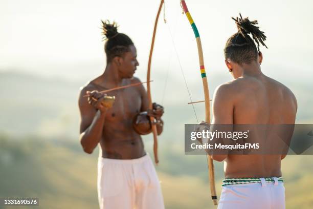 capoeira men playing berimbau - berimbau stock pictures, royalty-free photos & images