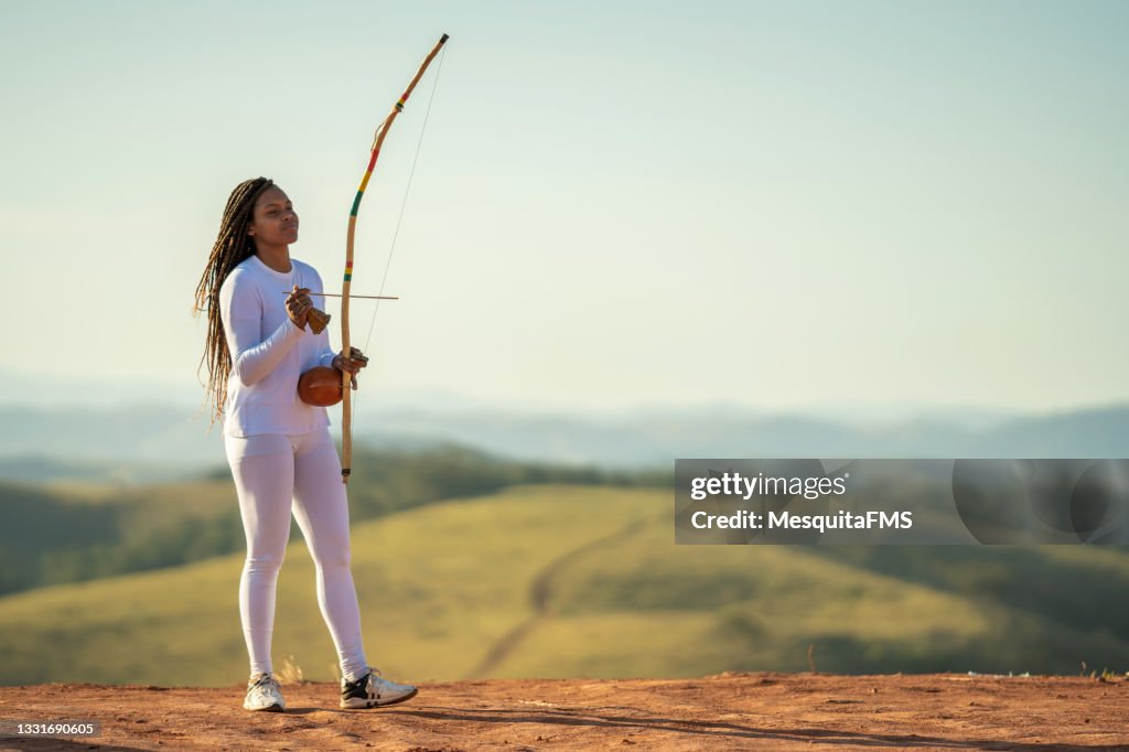 Capoeira woman playing berimbau