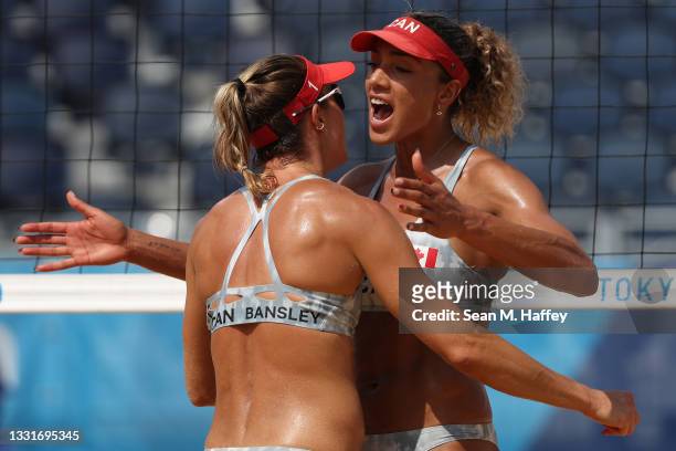 Heather Bansley of Team Canada celebrates with Brandie Wilkerson against Team United States during the Women's Round of 16 beach volleyball on day...