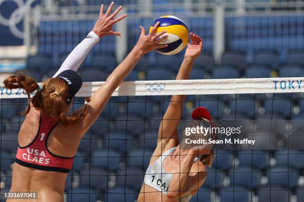 Kelly Claes of Team United States attempts to block the hit by Heather Bansley of Team Canada during the Women's Round of 16 beach volleyball on day...