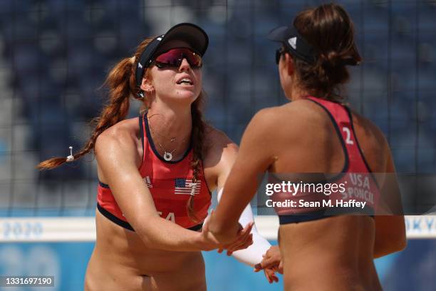 Kelly Claes of Team United States celebrates with Sarah Sponcil against Team Canada during the Women's Round of 16 beach volleyball on day nine of...