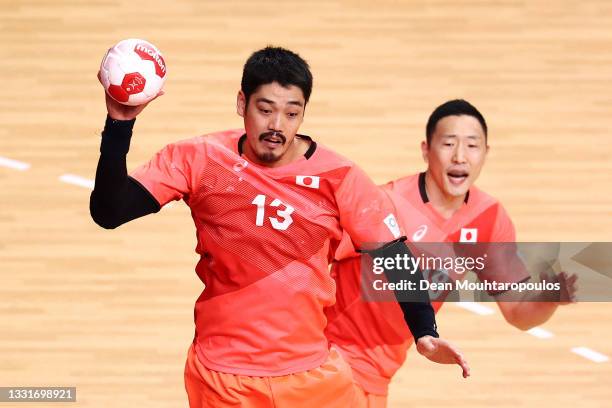 Kenya Kasahara of Team Japan passes the ball as teammate Kohei Narita of Team Japan watches on during the Men's Preliminary Round Group B handball...