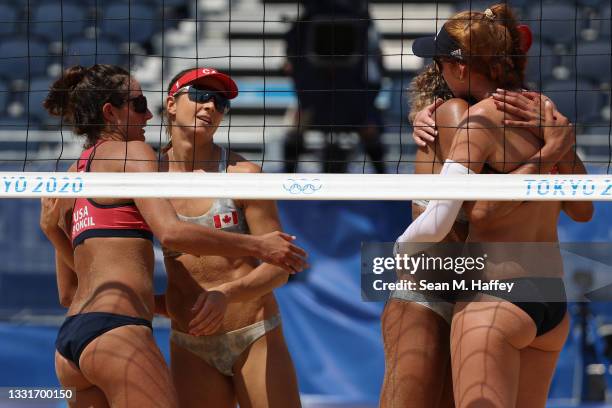 Team United States and Team Canada embrace after the Women's Round of 16 beach volleyball on day nine of the Tokyo 2020 Olympic Games at Shiokaze...