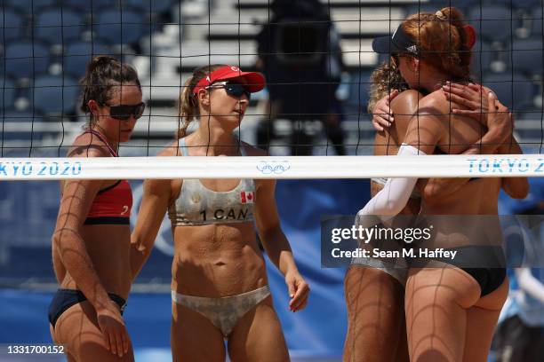 Team United States and Team Canada embrace after the Women's Round of 16 beach volleyball on day nine of the Tokyo 2020 Olympic Games at Shiokaze...
